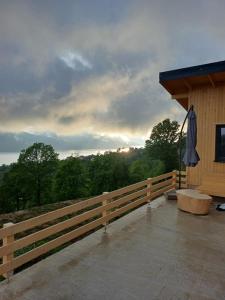 eine Veranda mit einem Holzzaun und einem Sonnenschirm in der Unterkunft Blue Paradise in Buhalniţa
