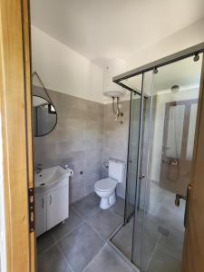 a bathroom with a toilet and a sink and a shower at Bungalovi Arabela in Utjeha