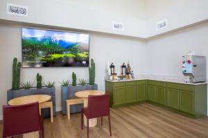 a room with two tables and a large painting on the wall at Kokopelli Inn Sedona, Trademark Collection by Wyndham in Sedona