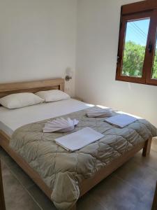 a bedroom with a large bed with pillows and a window at Bungalovi Arabela in Utjeha