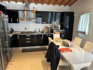 a kitchen with a white table with chairs and a kitchen with black cabinets at Vacanze toscane Relax privacy in San Baronto