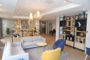 a living room with a white couch and chairs at Floridianes by HRI in Aix-en-Provence