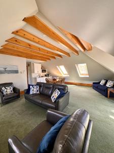 a living room with leather couches and a table at Harbourview Inn in Smiths Cove