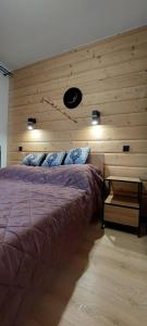 a bedroom with a bed and a wooden wall at Apartamenty Trzy Kopce SKI & BIKE & SAUNA in Ustroń +112 photos