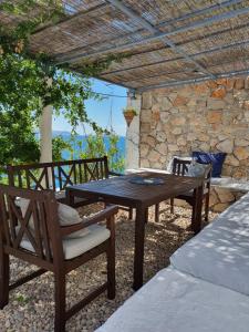 a wooden table and chairs on a patio at Kuća za odmor SeaHouse in Karlobag