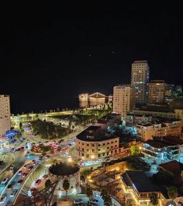 a city at night with traffic on a busy street at Rooms by Romi in Durrës