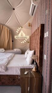 1 dormitorio con 1 cama y 1 mesa con mesita de noche en Rum world camp, en Wadi Rum