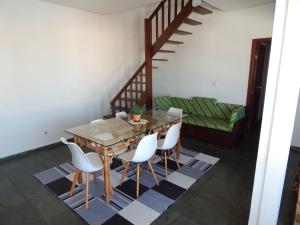 a dining room with a wooden table and white chairs at Cobertura de 3 Quartos Duplex in Cabo Frio