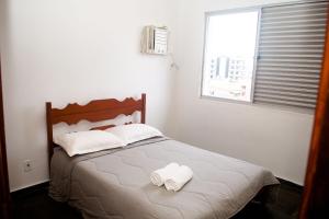 a bedroom with a bed with two towels on it at Cobertura de 3 Quartos Duplex in Cabo Frio