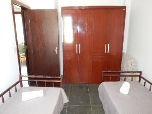 two beds in a room with wooden cabinets at Cobertura de 3 Quartos Duplex in Cabo Frio +55 photos