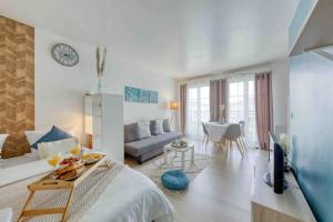 a white living room with a couch and a table at Le VanGogh - grand studio Disney 8 minutes in Bussy-Saint-Georges