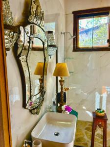 Segredo da Serra Guest House في تيرادينتيس: حمام مع حوض ومرايا على الحائط