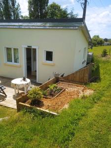 un jardín frente a una casa blanca en La petite maison au calme dans les champs, en Matton-et-Clémency