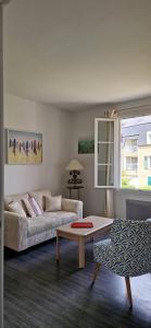 a living room with a couch and a coffee table at Bel appartement, 2 chambres, Parking, proximité plage et centre ville in Trouville-sur-Mer