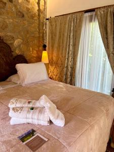 łóżko z ręcznikami i oknem w obiekcie Segredo da Serra Guest House w mieście Tiradentes