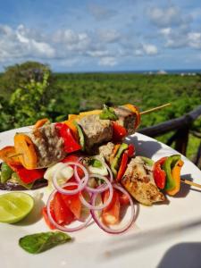 a plate of food with vegetables on a table at MONKEY MOUNTAIN LODGE in Mtende +125 photos