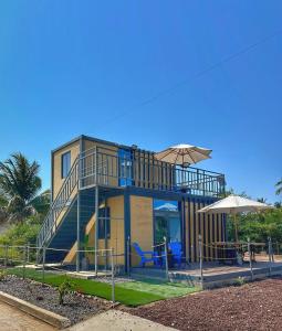 a house with a balcony and a patio at Yellow house 6 minutos de playa in Barra de Navidad