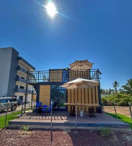 a building with a patio and an umbrella at Yellow house 6 minutos de playa in Barra de Navidad