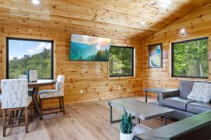 eine Blockhütte mit einem Tisch und einem Sofa in der Unterkunft Grand Vista View- Breathtaking Views, FREE tickets for each paid day, Hot Tub, WIFI in Sevierville + 45 Fotos