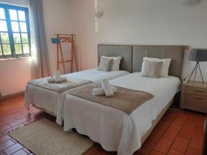 a bedroom with two beds with white sheets and pillows at Vicentina Rooms by Casas do Alentejo in Almograve