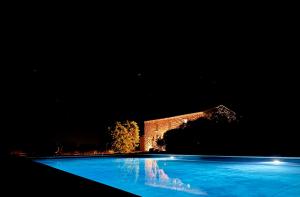 een zwembad voor een gebouw 's nachts bij Villa Maria Cristina in Santa Teresa Gallura
