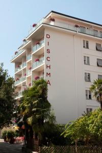 a hotel with a sign on the side of it at Hotel Dischma - FREE BUS AND TRAIN TICKET in Lugano