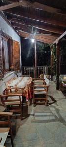 eine Terrasse mit einem Tisch, Stühlen und einer Decke in der Unterkunft Villa Ioannis in Skala Sotiros