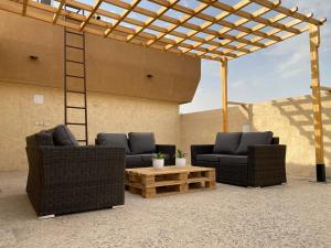 two wicker chairs and a table under a pergola at ليالي الخالدية سدو مع دخول ذاتي in Riyadh