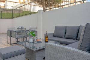a patio with a couch and a table with a bottle of wine at Terrace Beach Apartment in Buarcos