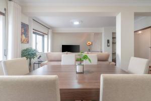 a dining room with a table and a couch at Terrace Beach Apartment in Buarcos