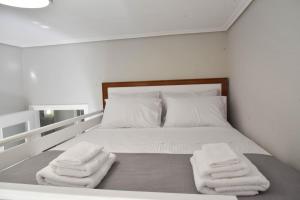a bedroom with a bed with two towels on it at F K Apartments in Artemida
