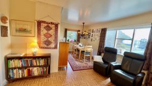 a living room with two chairs and a book shelf at Sunyard House Lofoten in Leknes