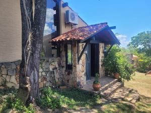 a stone house with a porch and a tree at La Soñada San Bernardino in San Bernardino