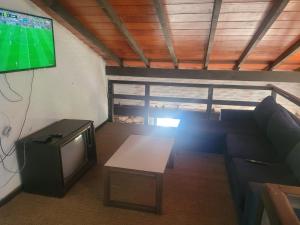 a living room with a tv and a couch and a table at La Soñada San Bernardino in San Bernardino +18 photos