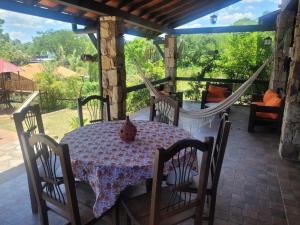 a porch with a table and chairs and a hammock at La Soñada San Bernardino in San Bernardino