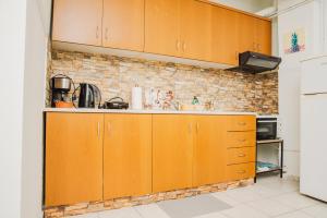 a kitchen with wooden cabinets and a brick wall at SOSEA in Alexandroupoli