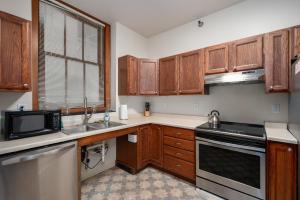uma cozinha com armários de madeira e um forno com placa de fogão em City Hall Recorder's Office em Rochester