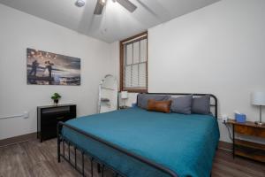 um quarto com uma cama com lençóis azuis e uma janela em City Hall Recorder's Office em Rochester