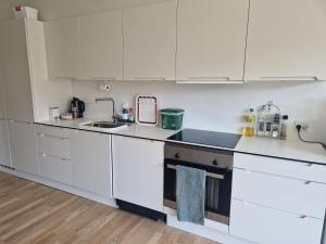 a kitchen with white cabinets and a sink at A charming apartment in the heart of Copenhagen in Copenhagen