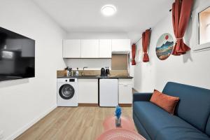 a living room with a blue couch and a kitchen at Douceur d'argile in Toulouse +20 photos