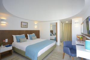 a hotel room with a bed and a tv at Monarque Dar Jerba Narjess in Taguermess