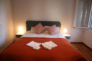 a bedroom with a bed with two towels on it at Alimos House in Athens