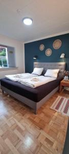 a bedroom with a large bed with a blue wall at The Dream Villa in Rødby