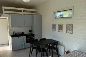 a kitchen with a table and chairs in a room at Gästhus i Nacka in Boo