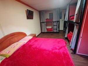 - une chambre avec un lit rouge et deux lits superposés dans l'établissement Yati Hostal, à La Paz