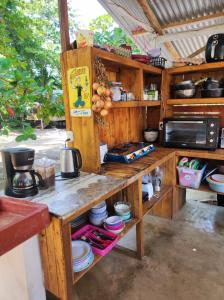 a kitchen with wooden shelves and a counter top at Camping Babsita in Tuba Creek