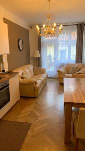 a living room with a couch and a chandelier at Anenska by Charles Bridge 3 in Prague