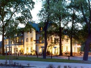 a large white building with trees in front of it at Landgasthof zum Mühlenteich in Eggersdorf