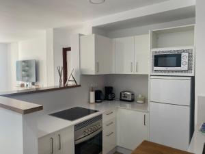 a kitchen with white cabinets and a microwave at El Rincón de Valentina 4B in Las Palmas de Gran Canaria