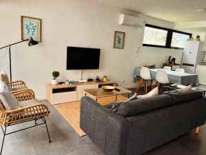 a living room with a couch and a flat screen tv at Domus Vallis in Furnas